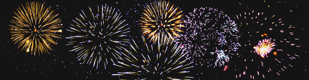 Colorful fireworks exploding against a black night sky.
