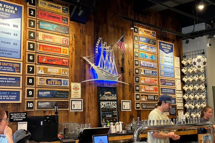 Bar with wooden decor, beer taps, menu boards, and nautical theme.