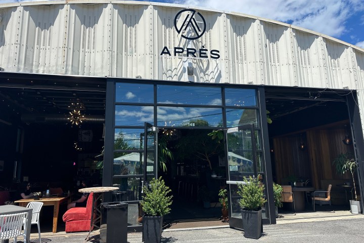 Industrial building with open glass doors, labeled 'APRÈS', greenery inside.